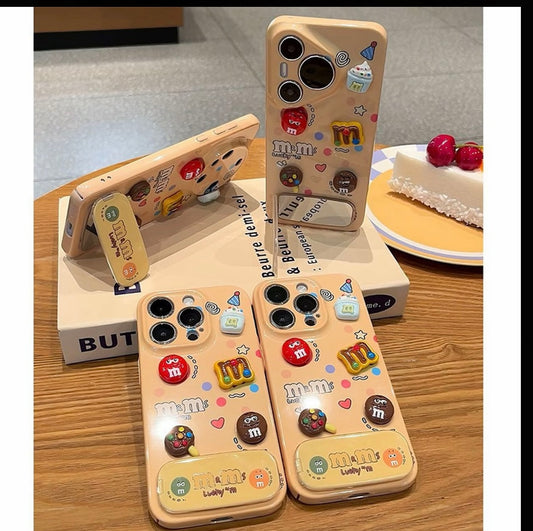 Bonita funda 3D para teléfono con diseño de M&M de frijol dulce, espejo de maquillaje plegable incorporado, soporte brillante a prueba de golpes para iPhone
